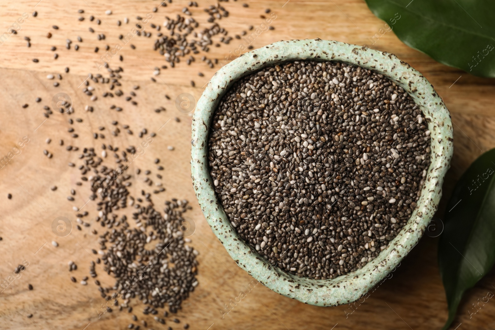 Photo of Bowl with chia seeds on wooden table, flat lay