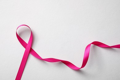 Photo of Pink ribbon on white background, top view. Breast cancer awareness concept