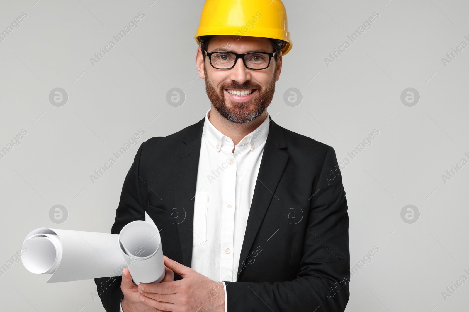 Photo of Architect in hard hat with drafts on gray background