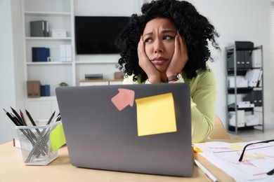Deadline concept. Stressed woman near laptop at wooden table in office