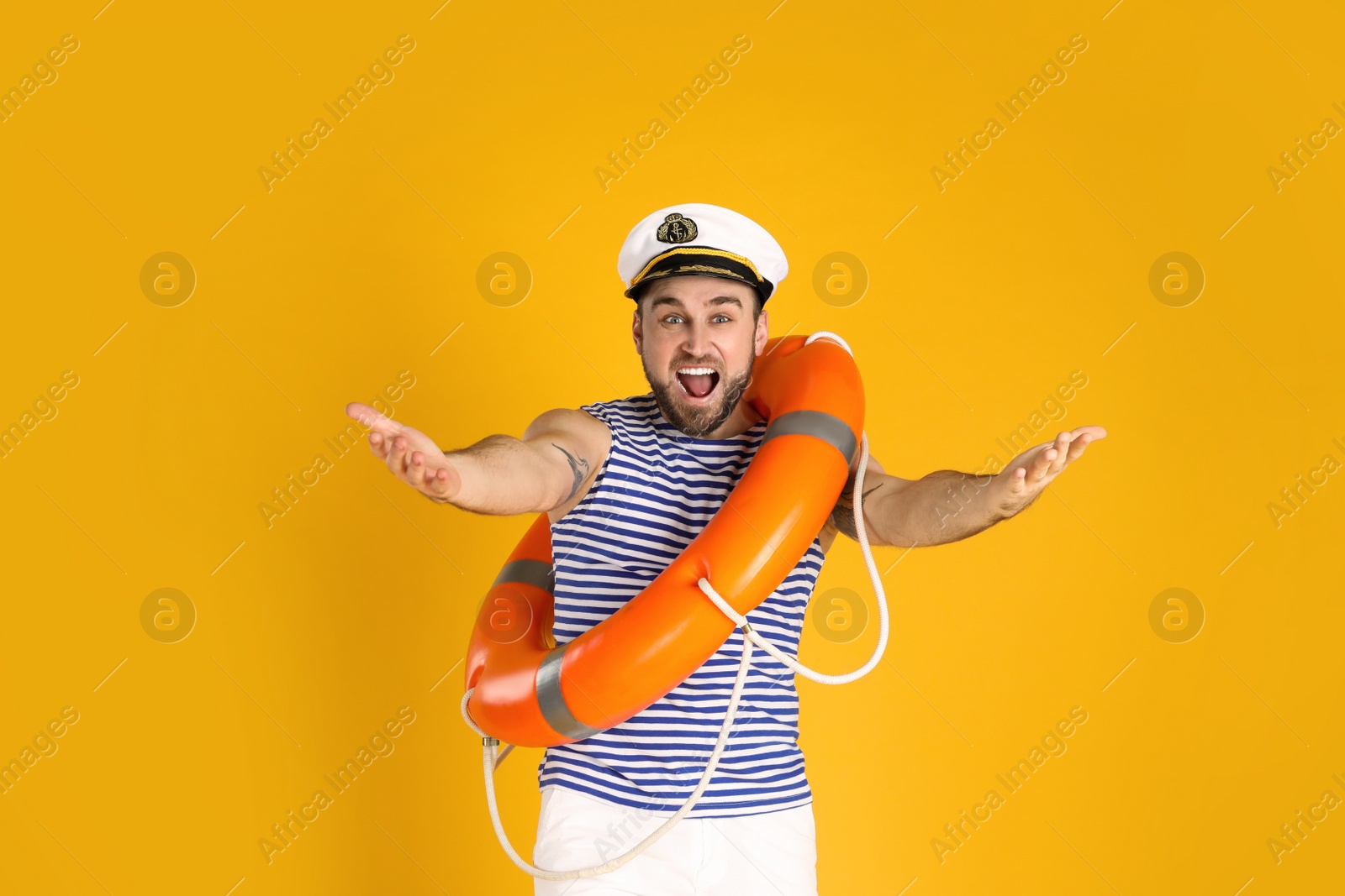 Photo of Happy sailor with ring buoy on yellow background