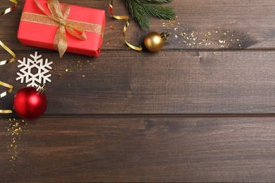 Photo of Flat lay composition with gift box and festive decor on wooden background, space for text. Happy New Year