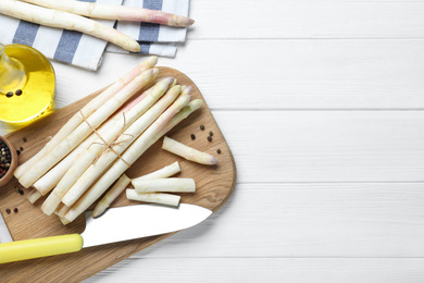 Photo of Fresh white asparagus on wooden table, flat lay. Space for text