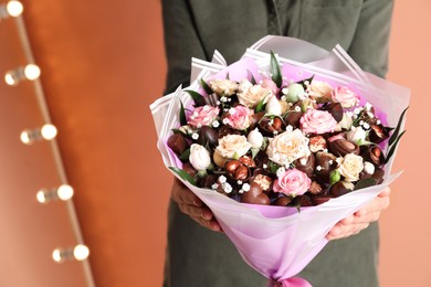 Photo of Woman with beautiful food bouquet on brown background, closeup