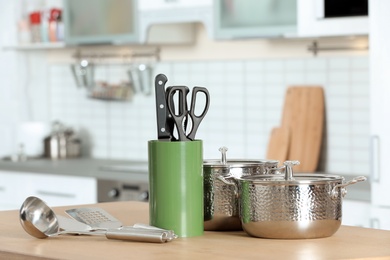 Photo of Set of clean cookware and utensils on table in kitchen. Space for text