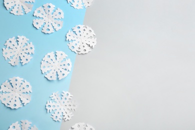 Many paper snowflakes on color background, flat lay. Space for text