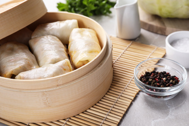 Photo of Delicious cabbage rolls served on light grey marble table, closeup