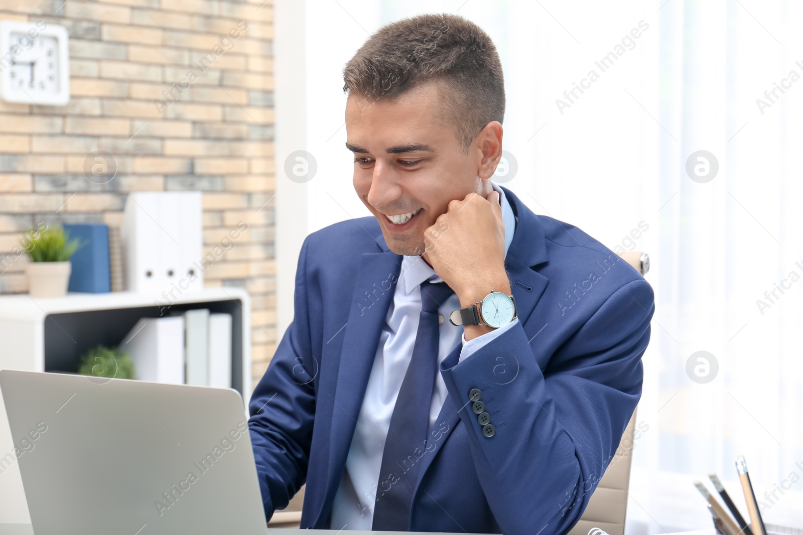 Photo of Man in office wear using laptop indoors