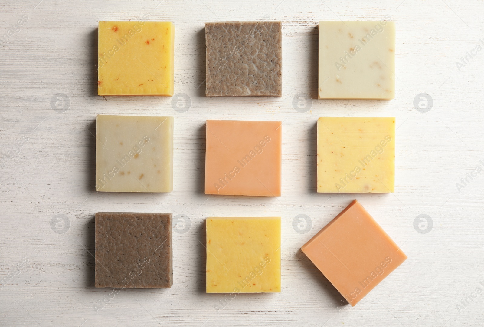 Photo of Hand made soap bars on white wooden background, top view