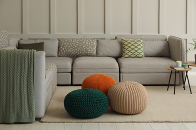 Living room interior with different stylish knitted poufs and sofa