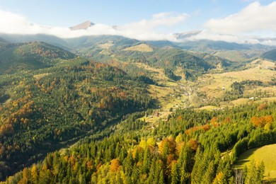 Image of Aerial view of beautiful mountain forest and village on autumn day