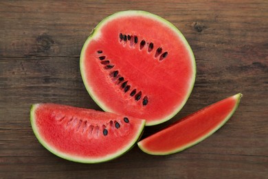 Delicious cut watermelons on wooden table, flat lay