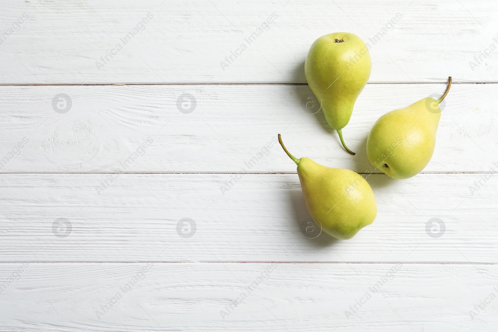 Photo of Ripe pears on wooden background, top view. Space for text