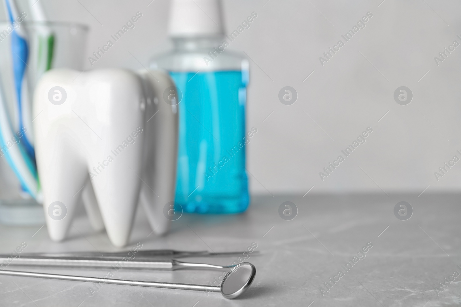 Photo of Dentist tools and tooth shaped holder on table. Space for text