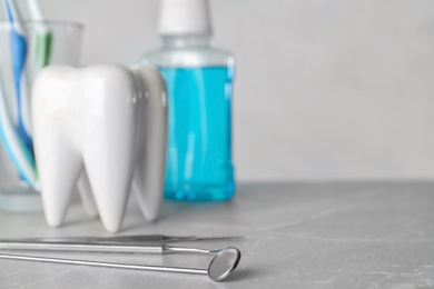 Photo of Dentist tools and tooth shaped holder on table. Space for text