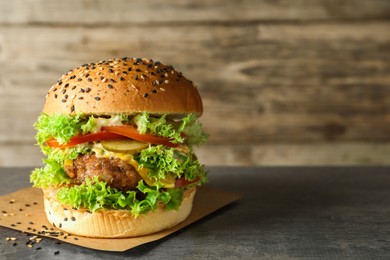 Photo of Burger with delicious patty on gray table, space for text