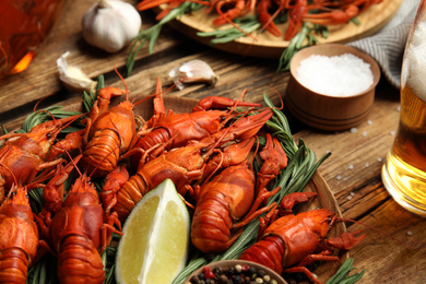 Delicious red boiled crayfishes on wooden table, closeup