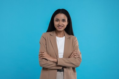 Portrait of beautiful secretary on light blue background