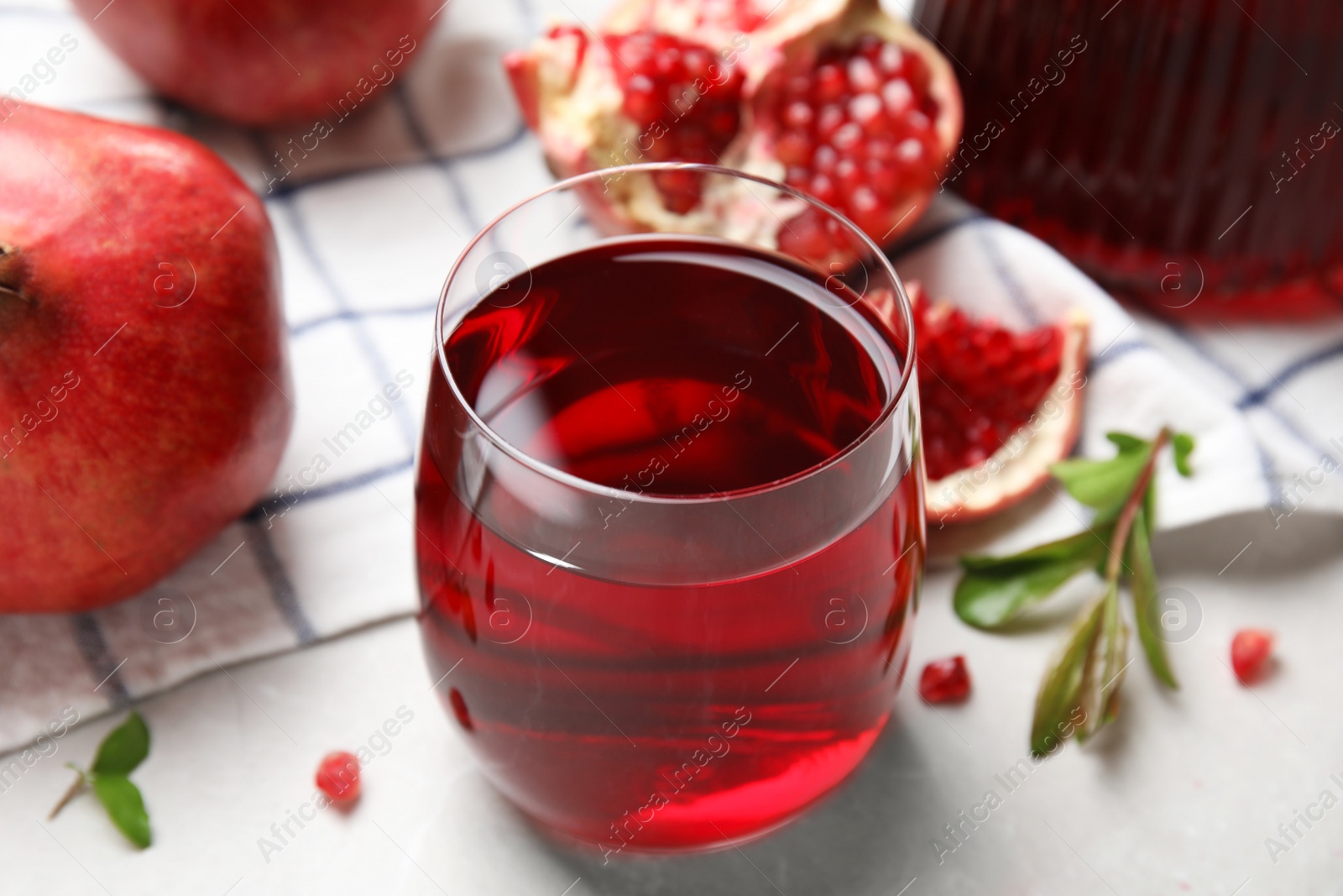 Photo of Glass of pomegranate juice and fresh fruits on white table