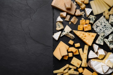 Photo of Cheese plate on black table, top view. Space for text