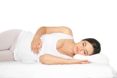 Photo of Beautiful pregnant woman sleeping with orthopedic pillow on bed against white background