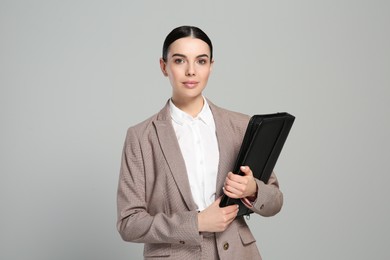 Photo of Beautiful real estate agent with documents on grey background