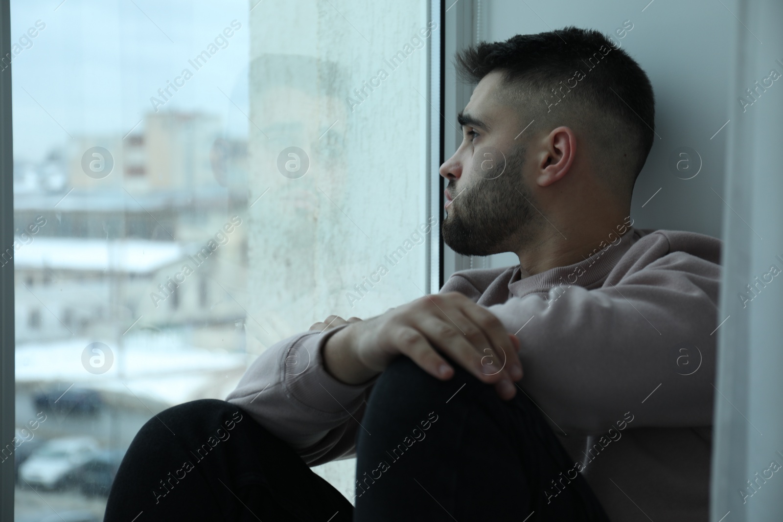 Photo of Sad man looking at window at home