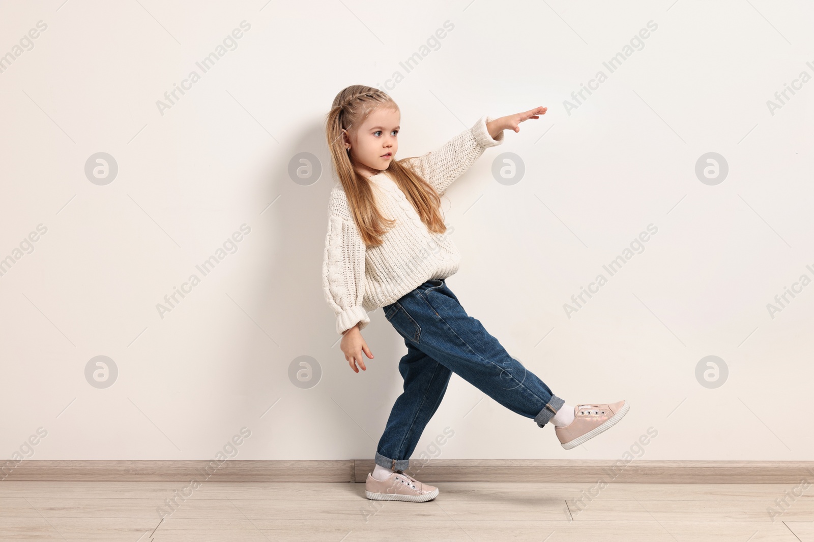 Photo of Fashion concept. Stylish girl posing near white wall