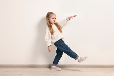 Fashion concept. Stylish girl posing near white wall