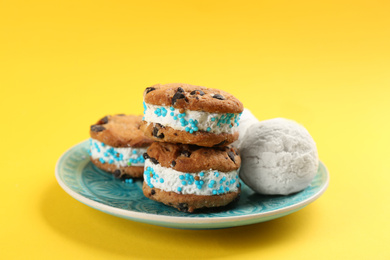 Sweet delicious ice cream cookie sandwiches on yellow background