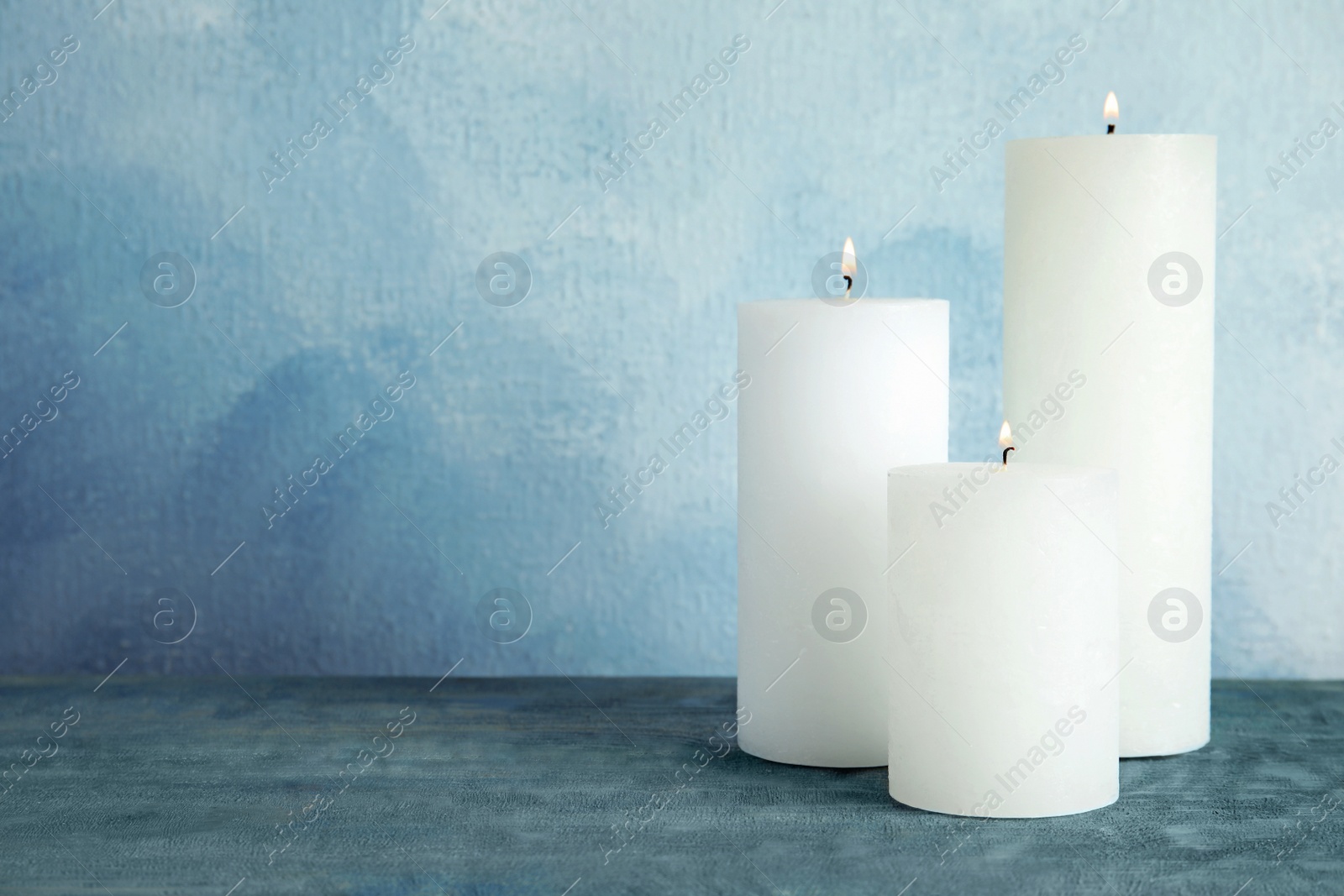 Photo of Alight wax candles on table. Space for text