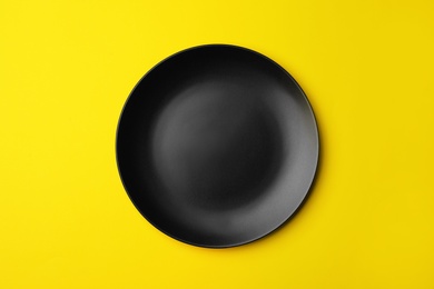 Clean empty plate on color background, top view