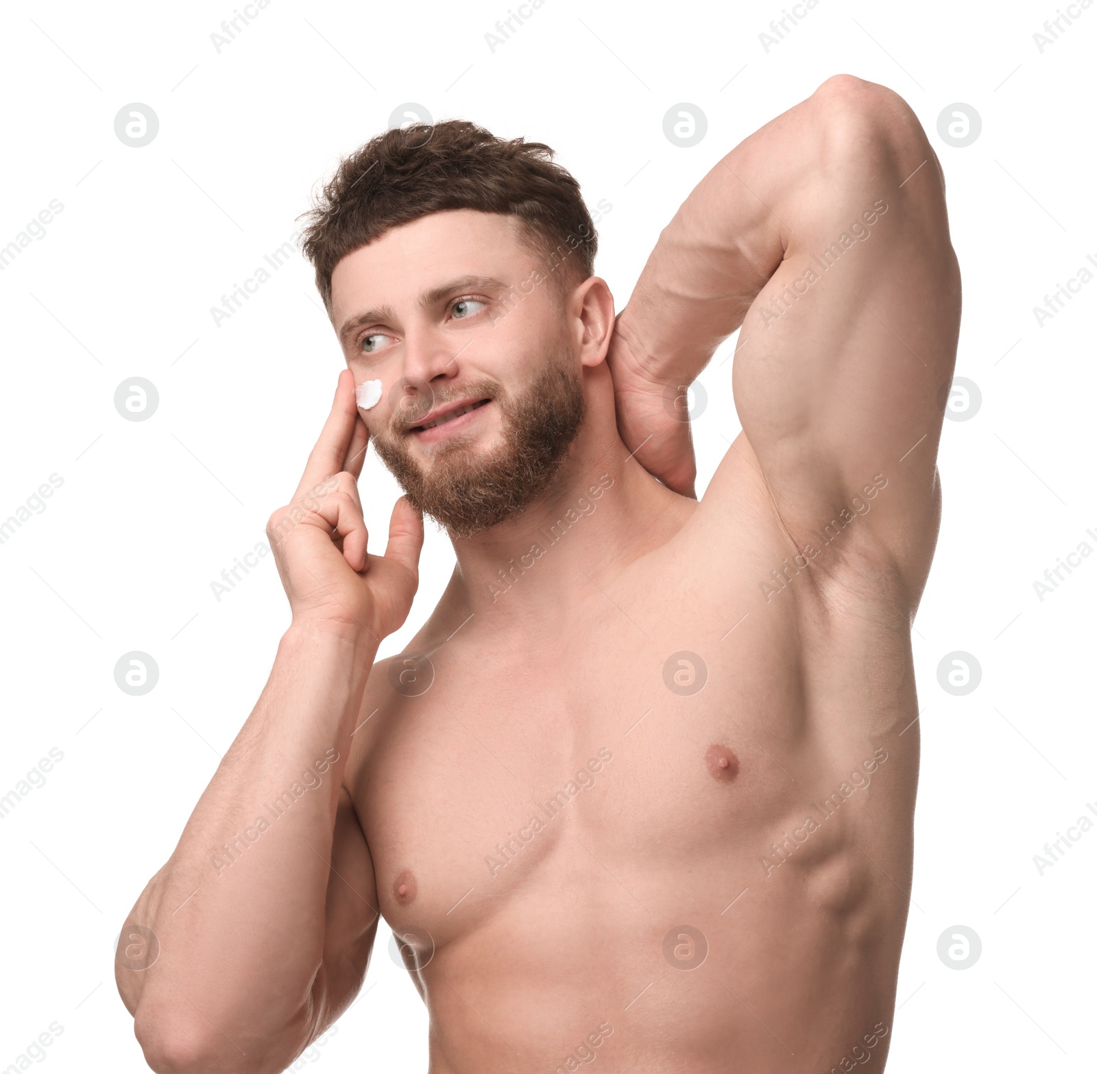 Photo of Handsome man applying moisturizing cream onto his face on white background