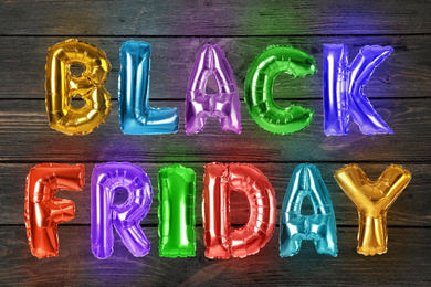 Image of Phrase BLACK FRIDAY made of foil balloon letters on wooden background