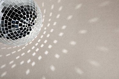 Photo of Shiny disco ball on light grey background, top view. Space for text