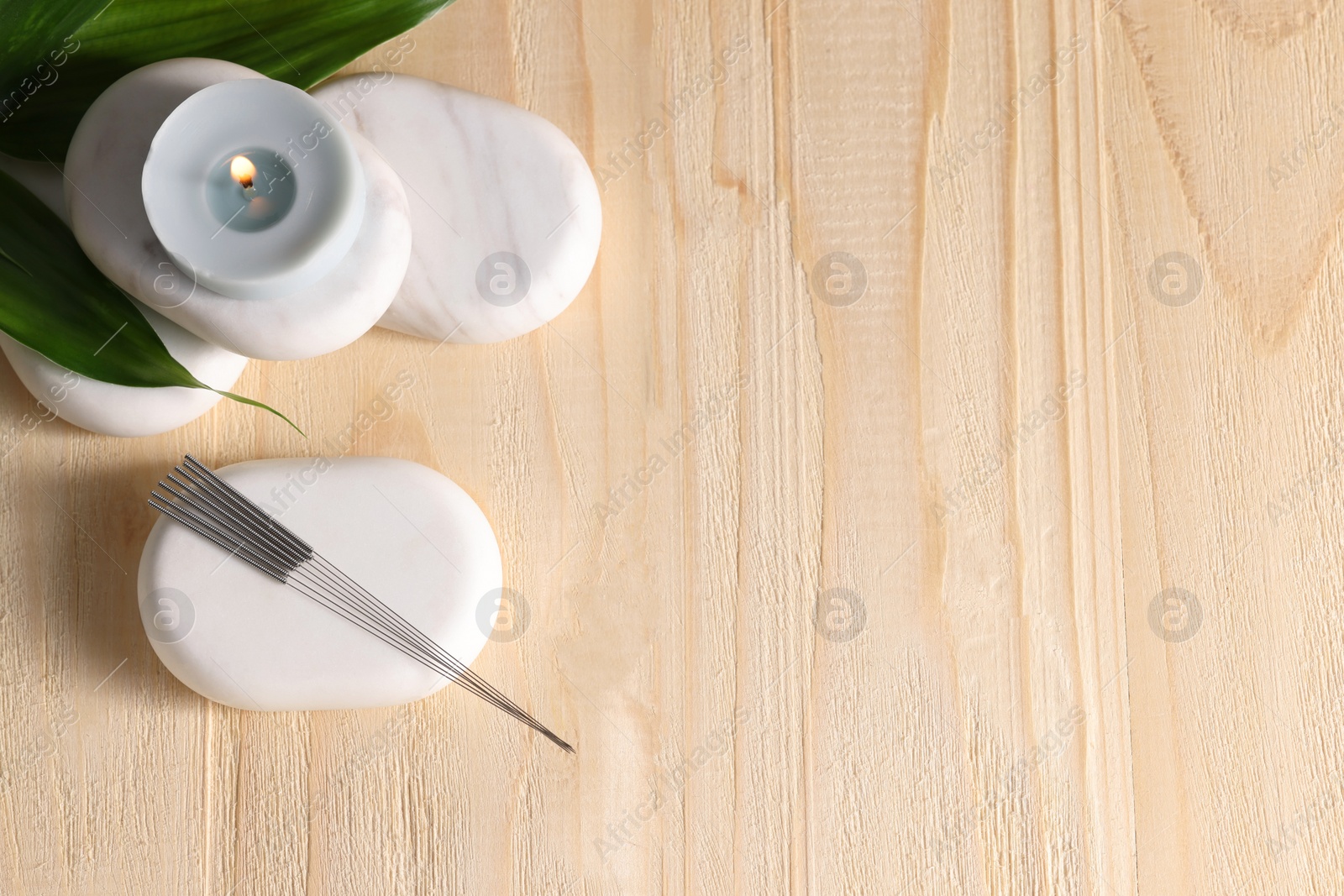 Photo of Flat lay composition with acupuncture needles on wooden table, space for text