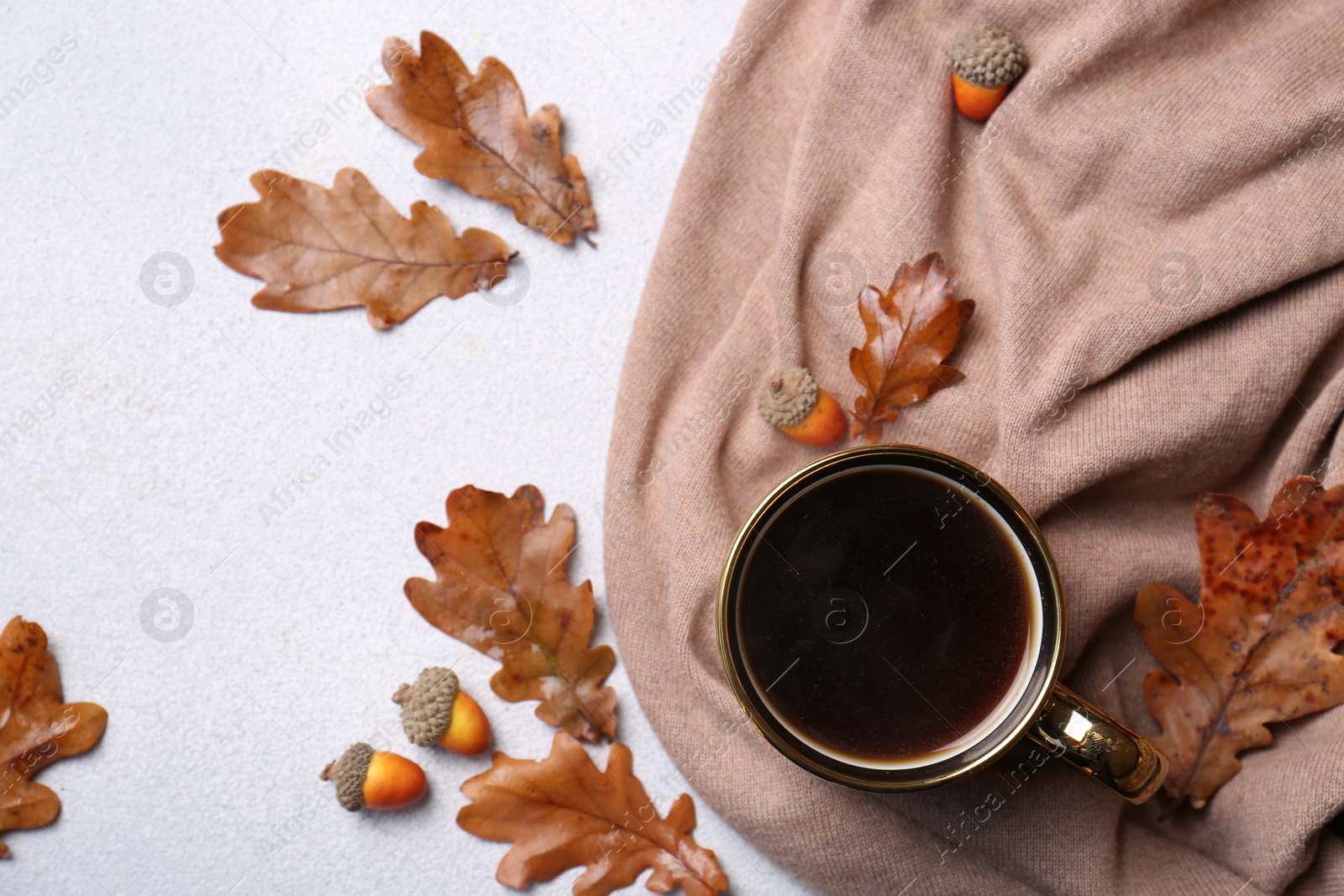 Photo of Flat lay composition with cup of hot drink and autumn leaves on light grey textured table. Space for text