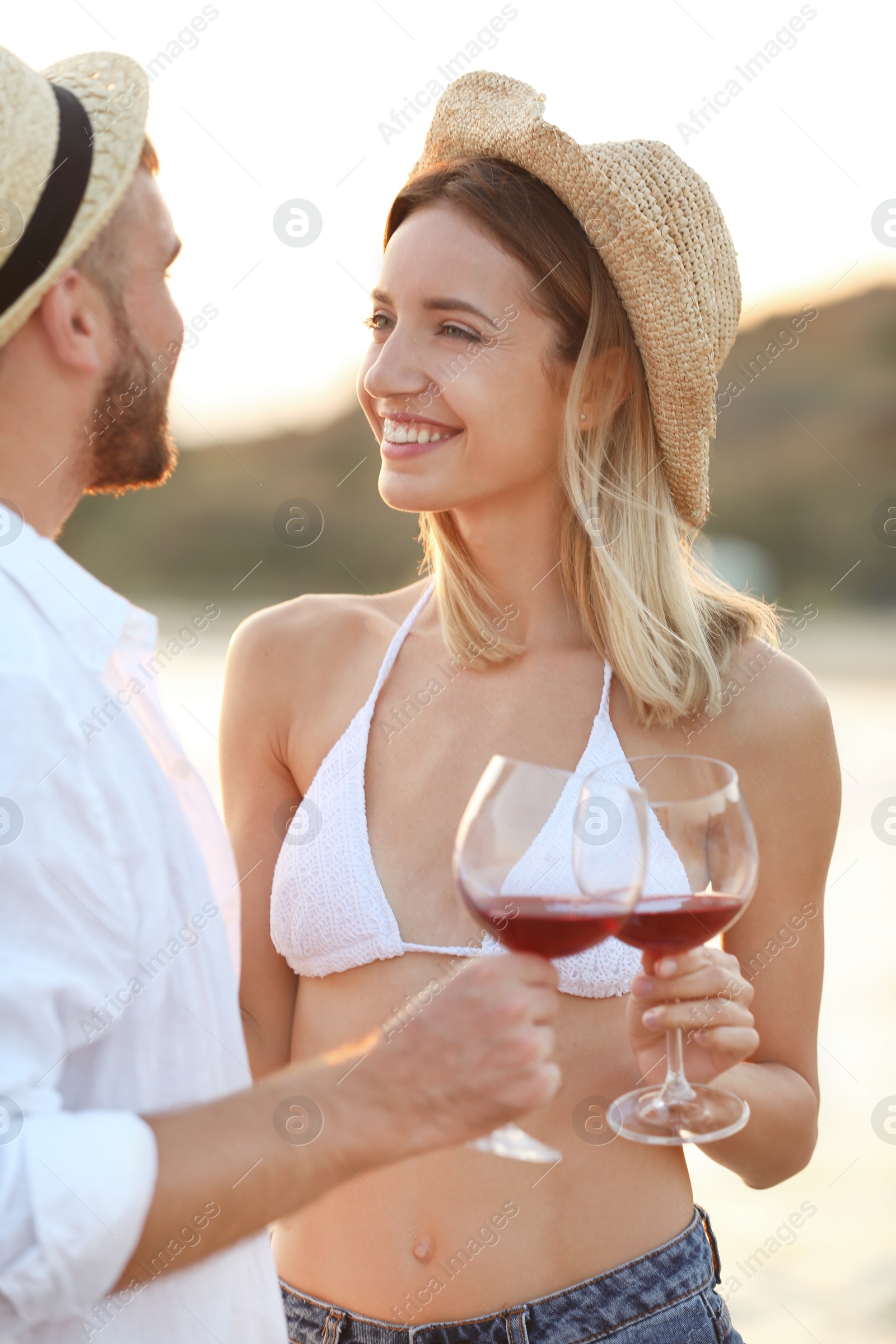 Photo of Young couple with glasses of wine on beach