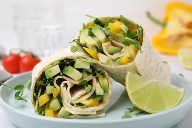 Photo of Delicious sandwich wraps with fresh vegetables and slice of lime on plate, closeup