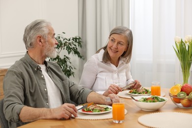 Happy senior couple having dinner at home