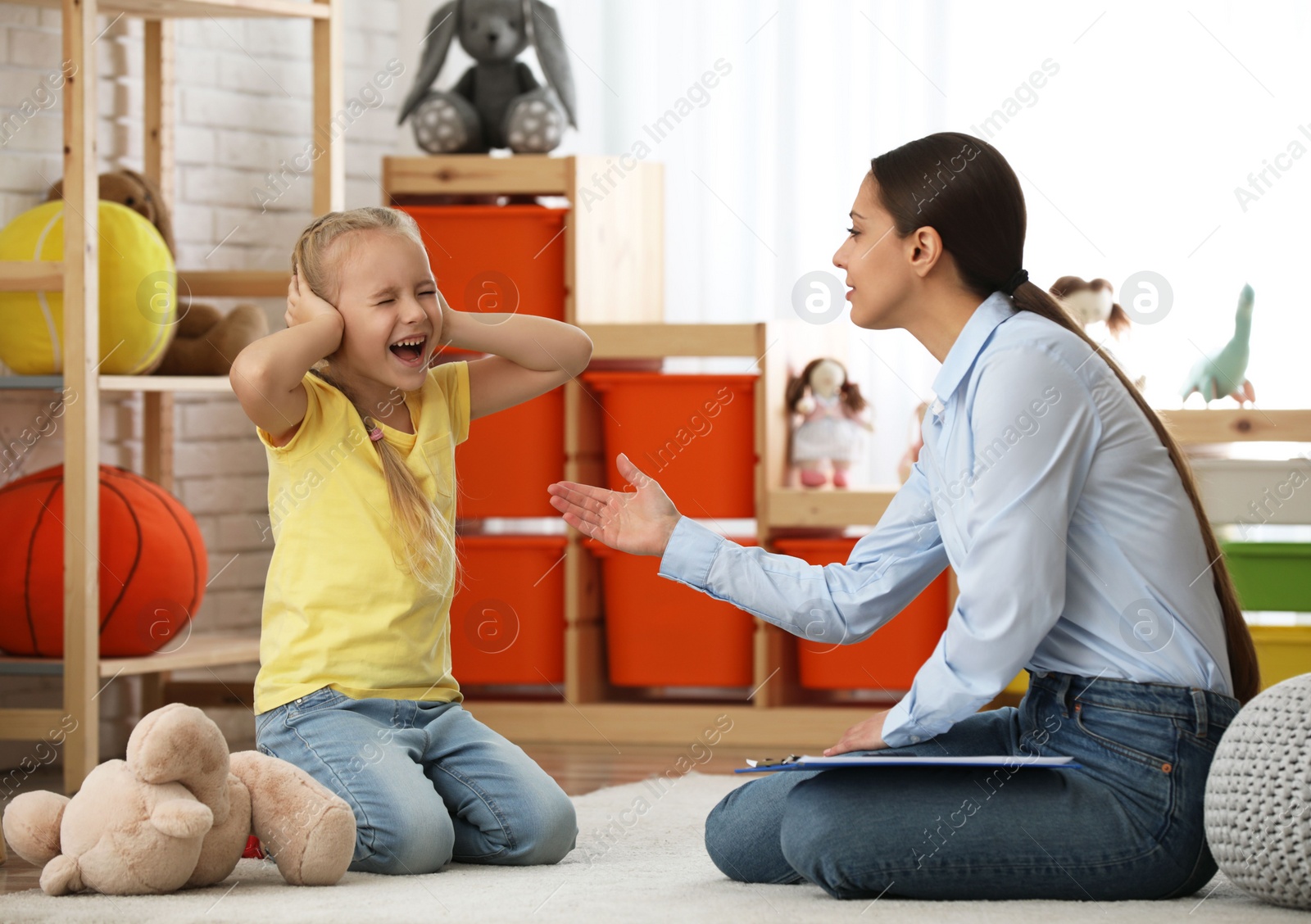 Photo of Child psychotherapist working with little girl in office