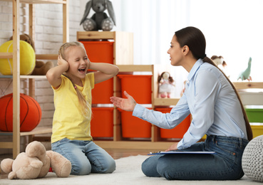 Photo of Child psychotherapist working with little girl in office