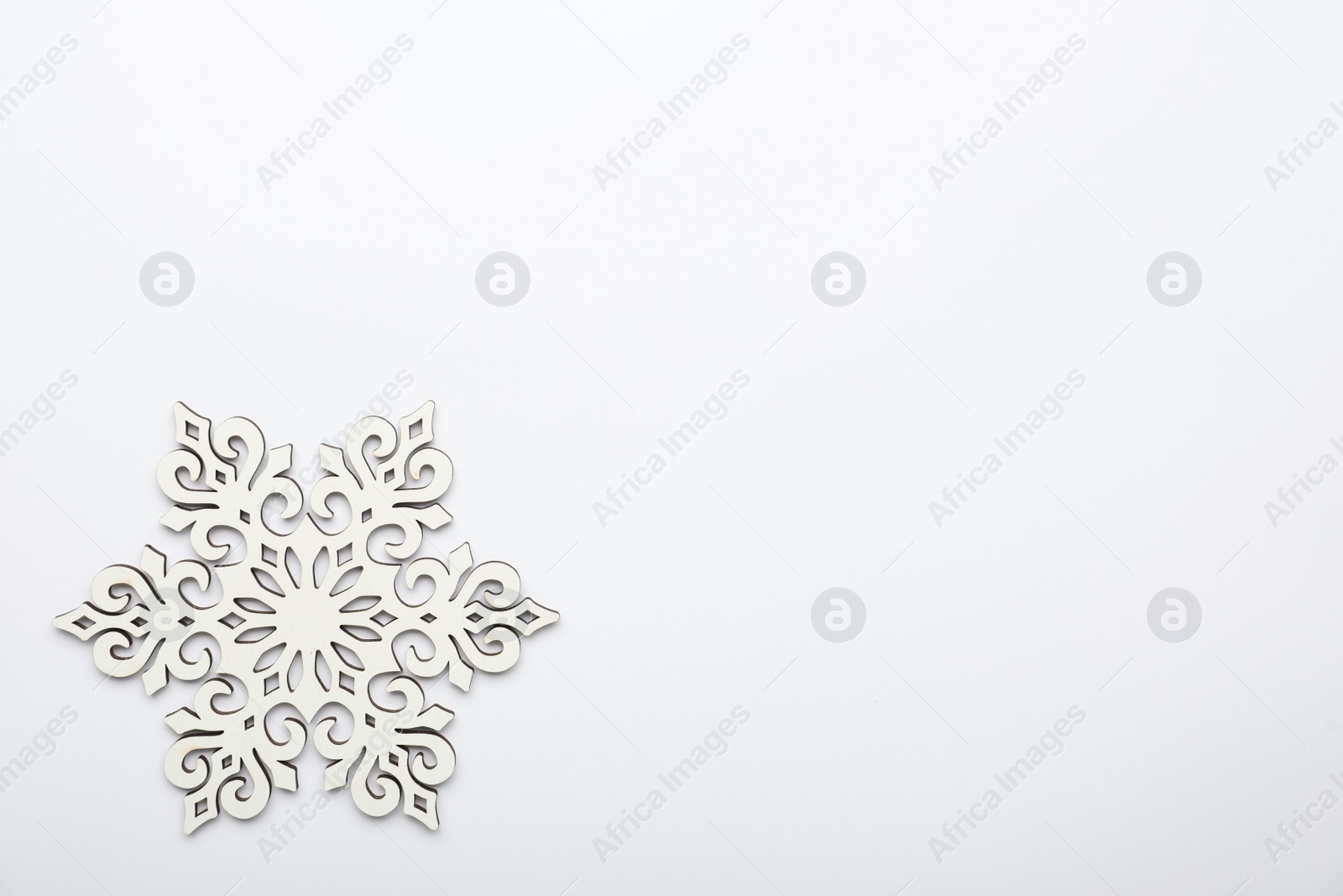 Photo of Beautiful decorative snowflake on white background, top view. Space for text