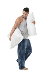 Young man with soft pillows on white background