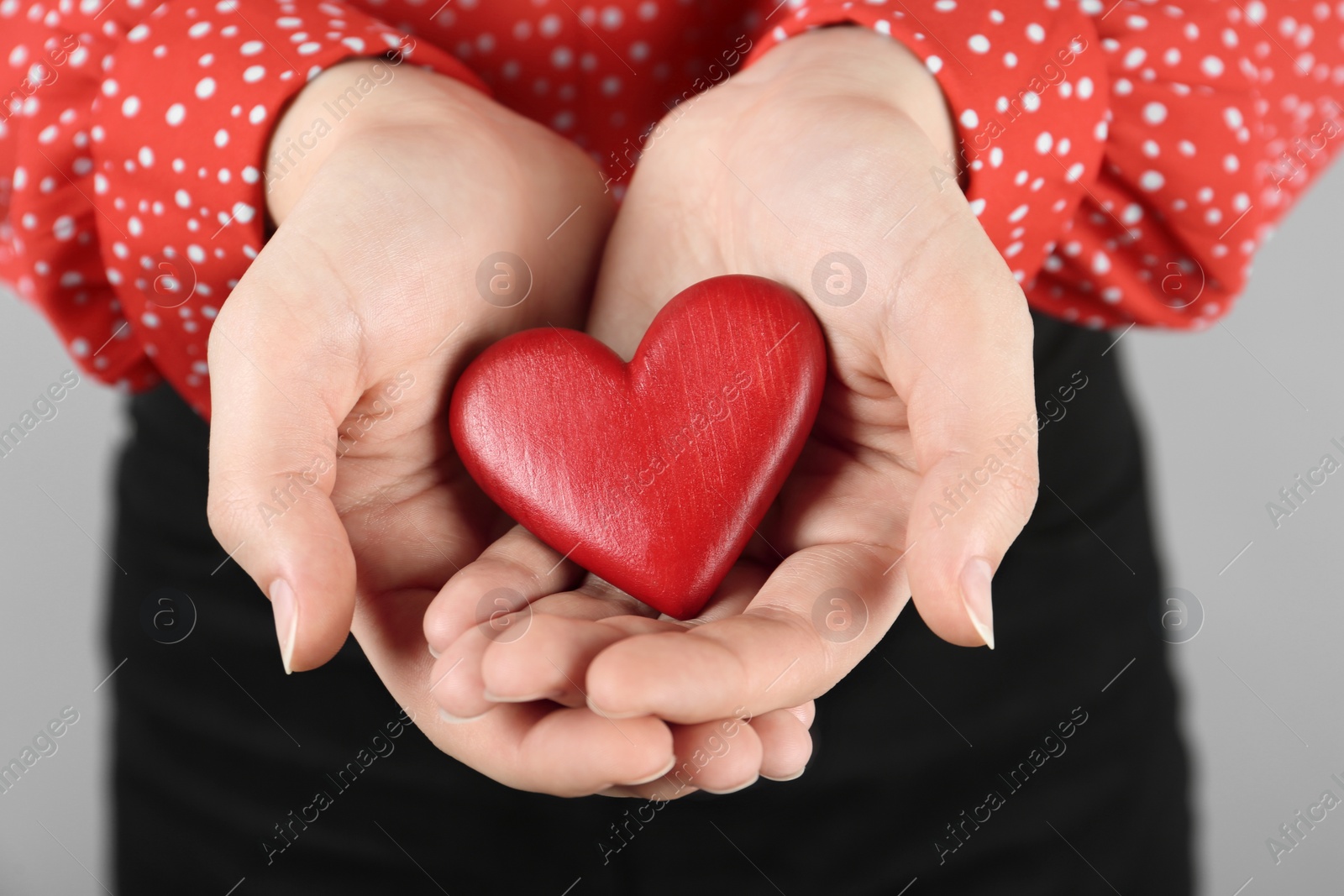 Photo of Woman holding red heart on grey background, closeup. Happy Valentine's Day