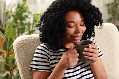 Relaxing atmosphere. Woman with cup of hot drink near houseplants at home