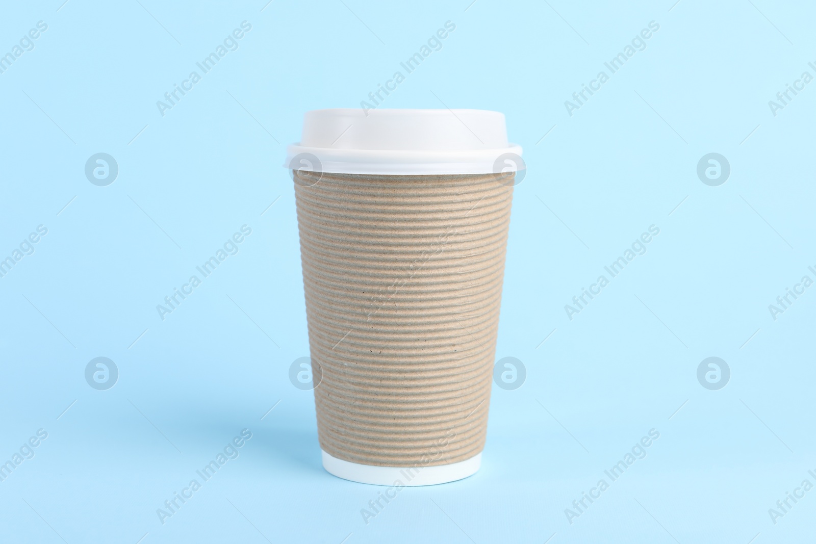 Photo of Paper cup with plastic lid on light blue background. Coffee to go