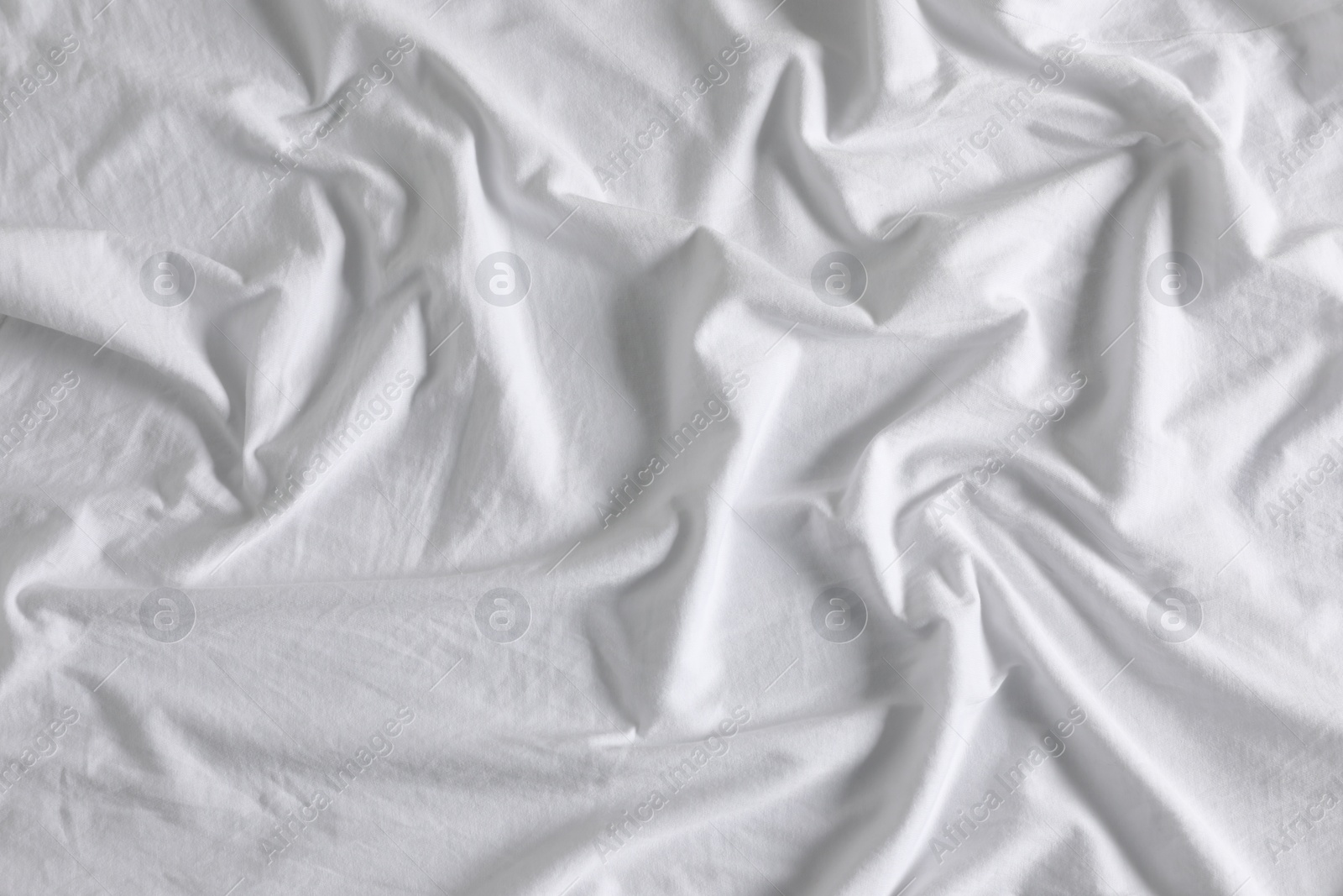 Photo of Crumpled white fabric as background, closeup view