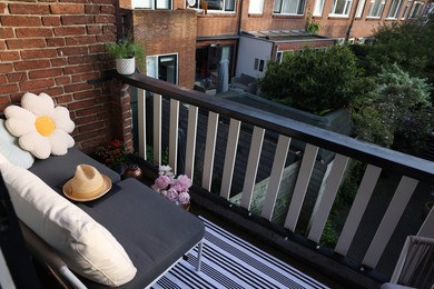 Soft chairs, hat and plants at cozy balcony