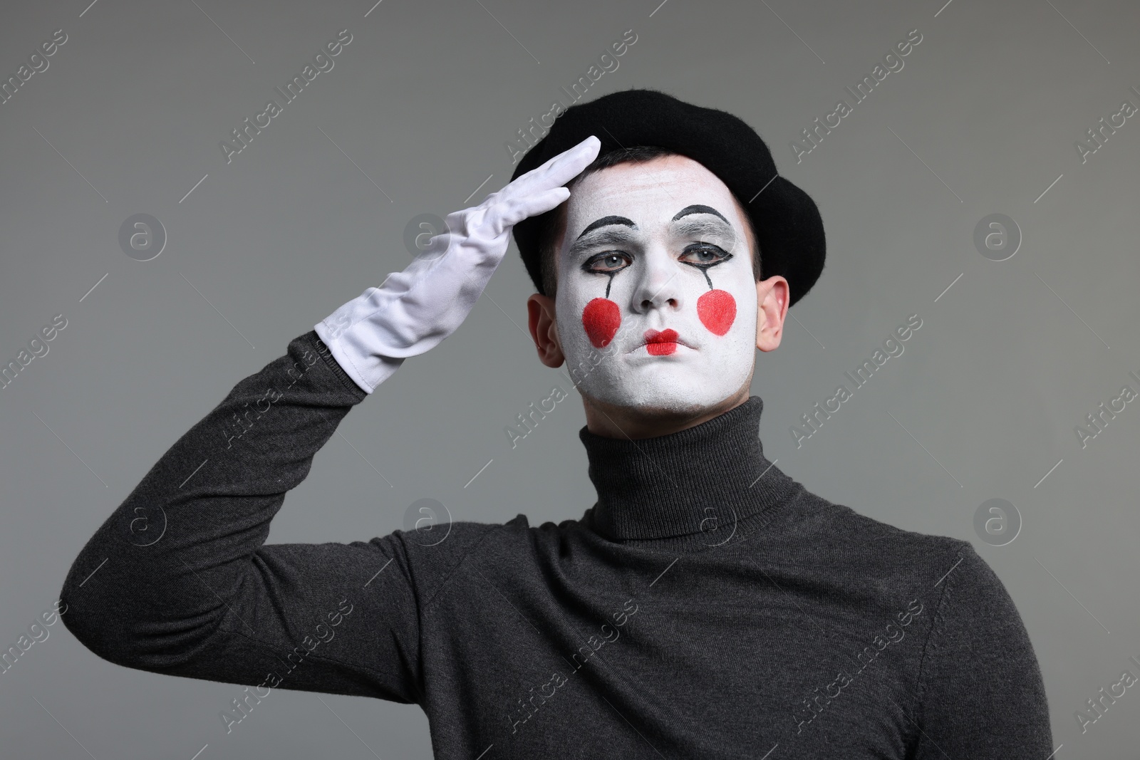 Photo of Mime artist in beret posing on grey background